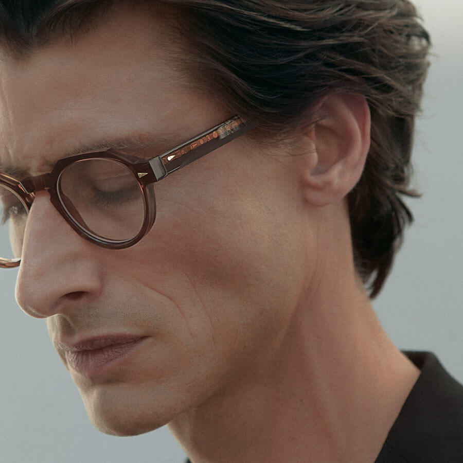 Male fashion model wearing luxe acetate Ahlem glasses.