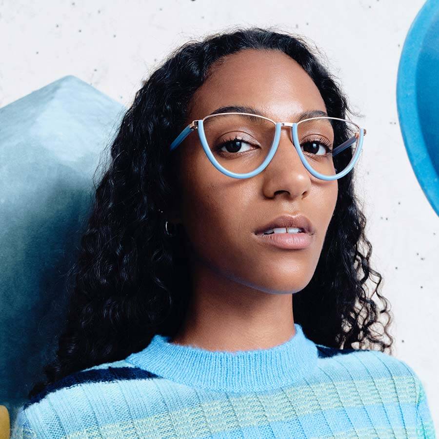 Model wearing blue Andy Wolf glasses and a matching blue jumper.