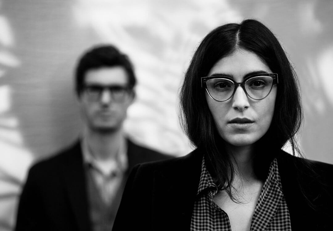 A fashion shoot in black and white with a male and female model wearing Ahlem designer glasses.