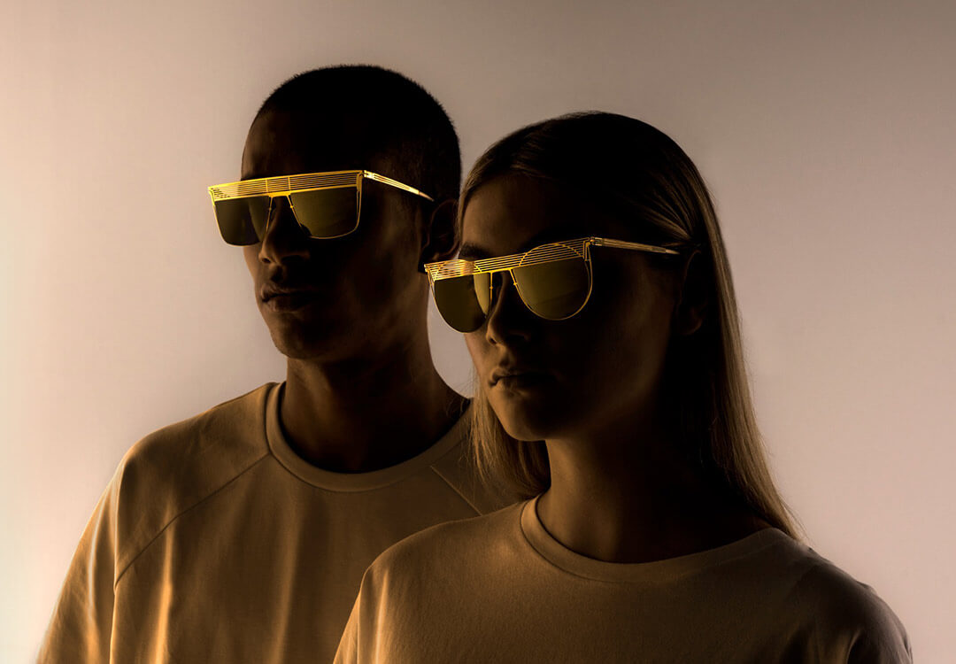 Two models standing in shadow wearing designer statement glasses by lool.