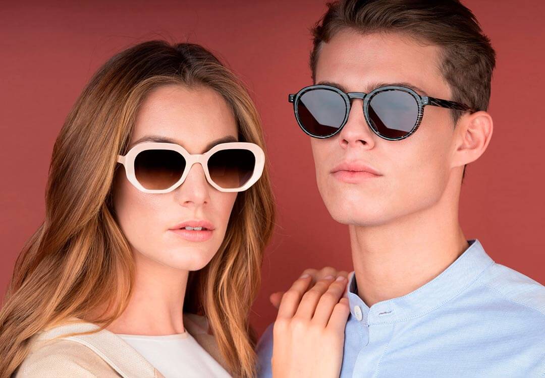 Female and male model wearing designer Res Rei sunglasses with classic frames.