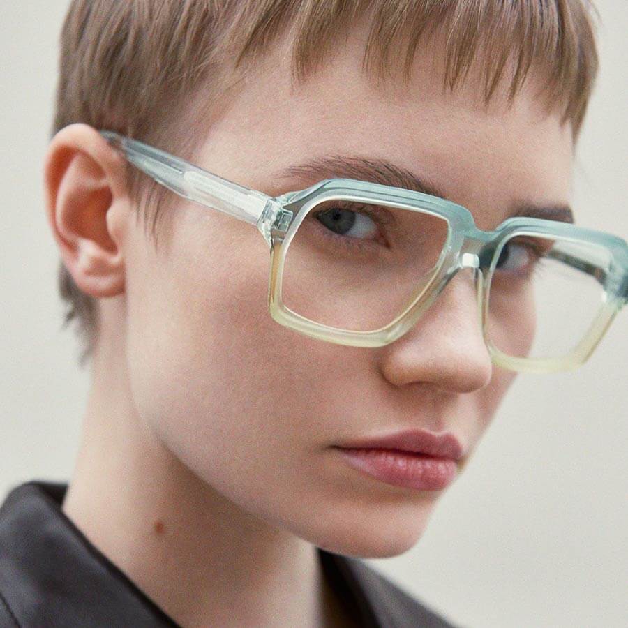 Woman with a fashionable pixie cut wearing Folc eyewear, with laminated acetate frames.