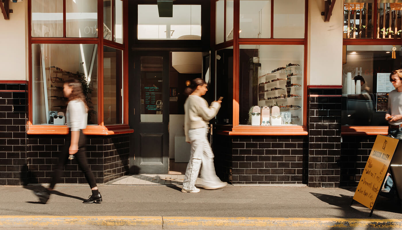 Customers walking past the shopfront of Peep Optical, an optometrist in Yarraville.